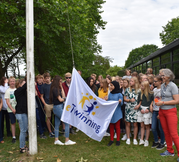Flag med e-twinning hejses af elever og lærere